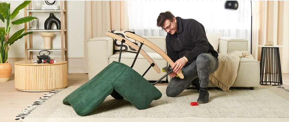 Homme souriant en train d'assembler un fauteuil à bascule vert